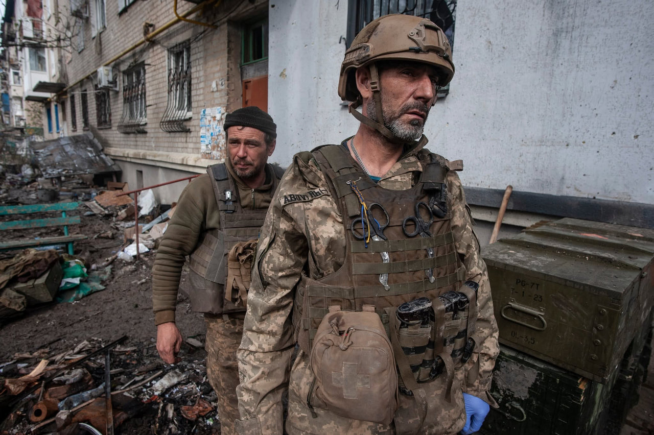 Servicemembers outside an apartment building.