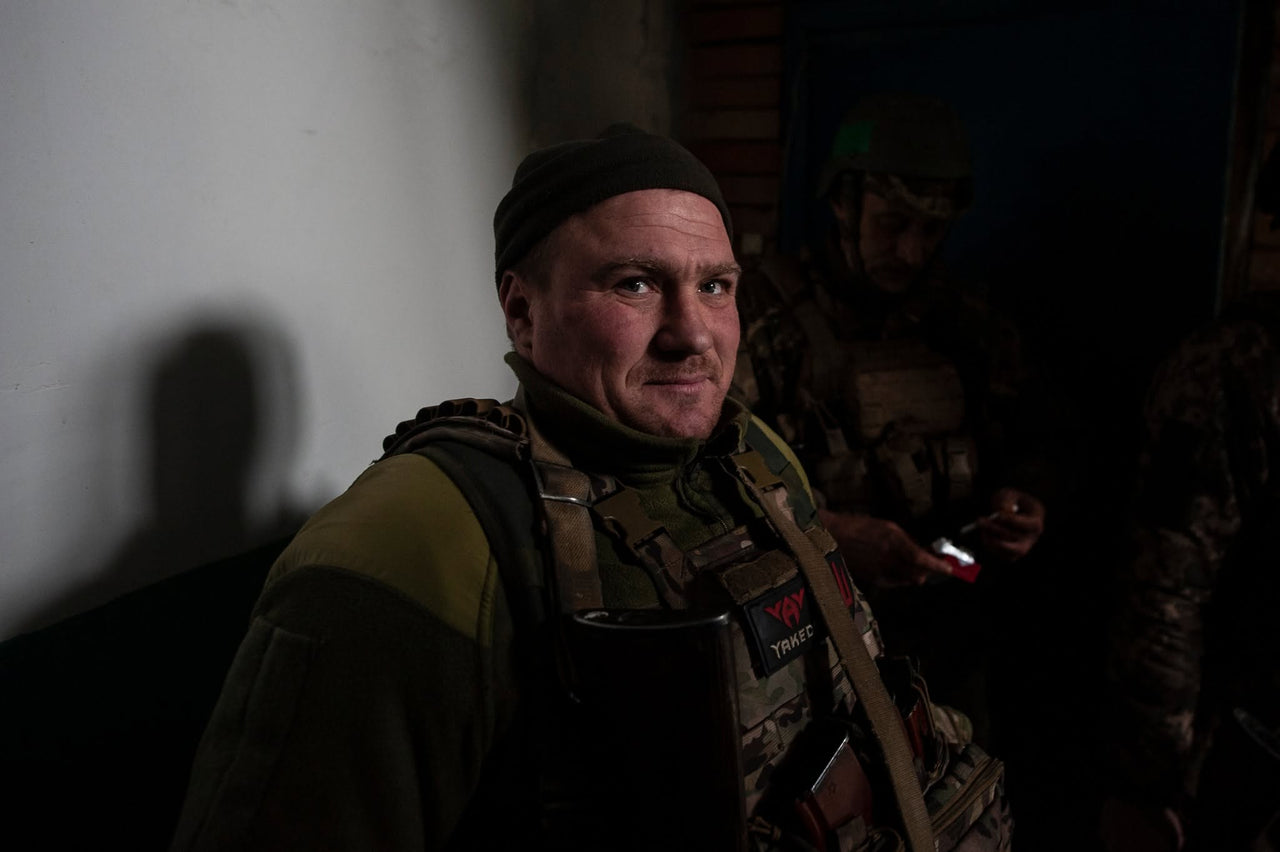 Portrait of a servicemember in a dark interior.